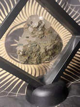 Load image into Gallery viewer, Clear quartz cluster with pyrite peacock ore specimen in black floating frame
